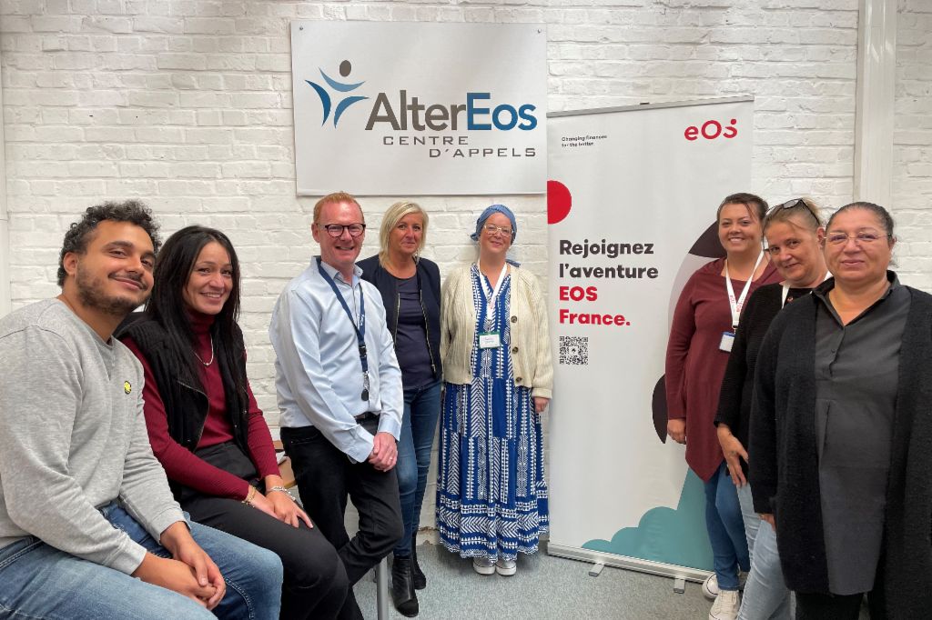 A group of eight people standing in front of an EOS banner and an AlterEOS banner facing the camera.